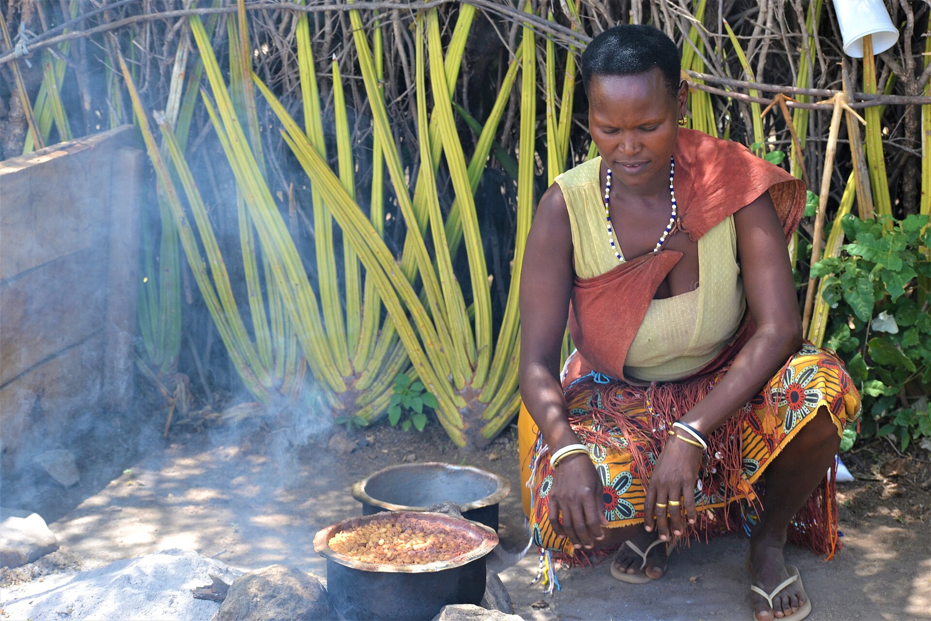 A woman cooking on a stove in a village