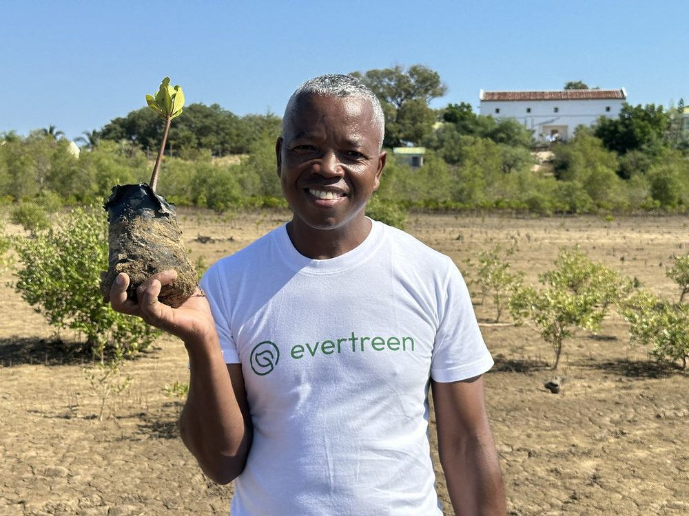 A community member smiling with a mangrove seedling, Madagascar